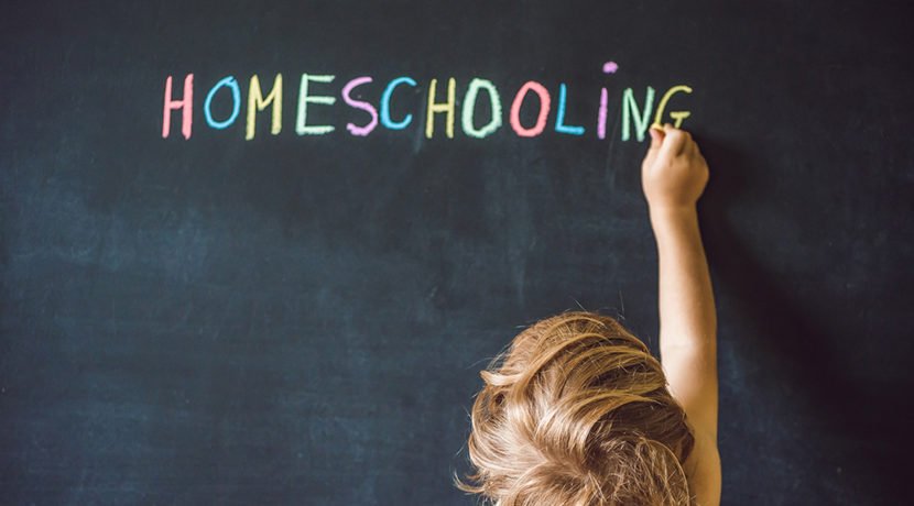 a child writing homeschooling on a black board